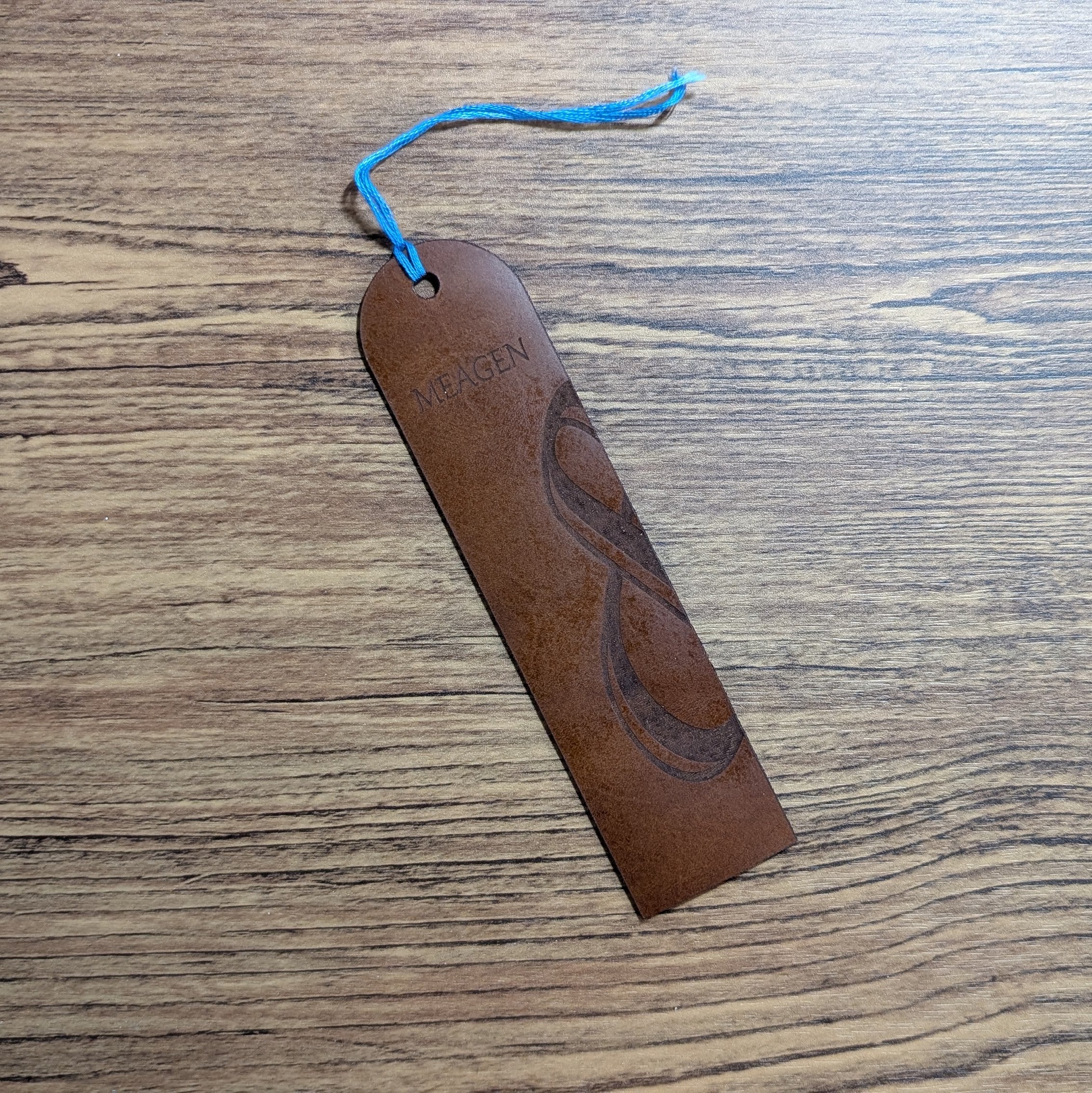 Single tan leather bookmark with an engraved ampersand design